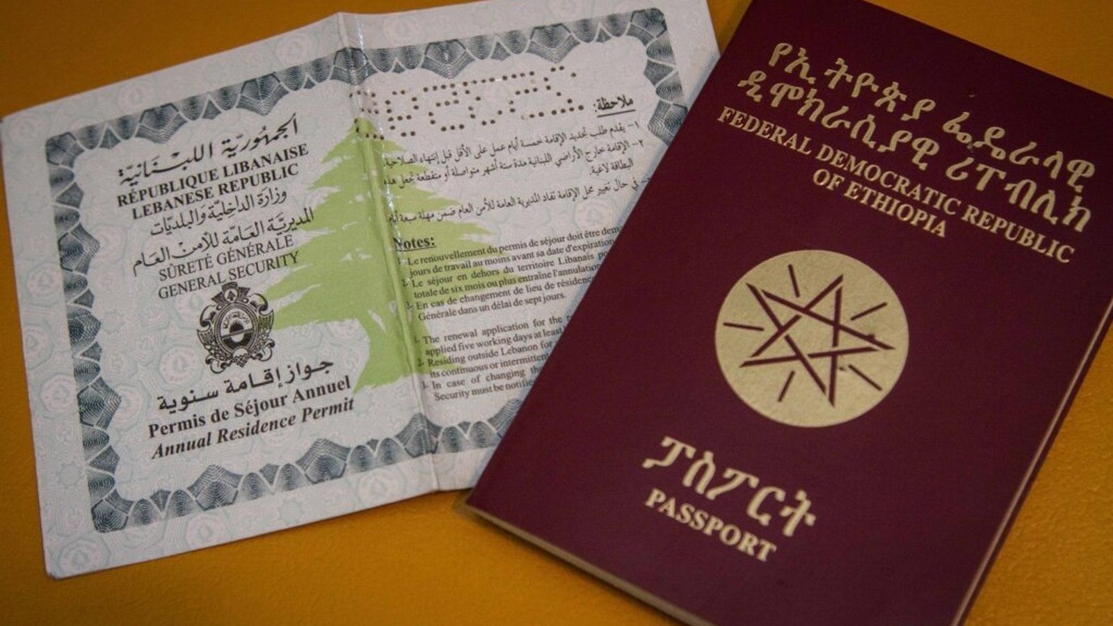 An Ethiopian passport beside a Lebanese annual residence permit